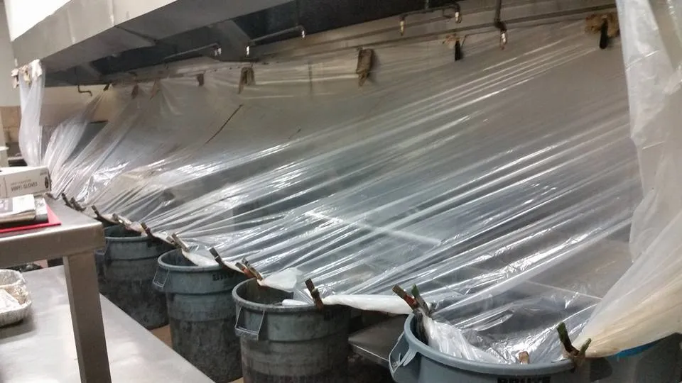 Hood cleaning technician cleaning a commercial kitchen exhaust system